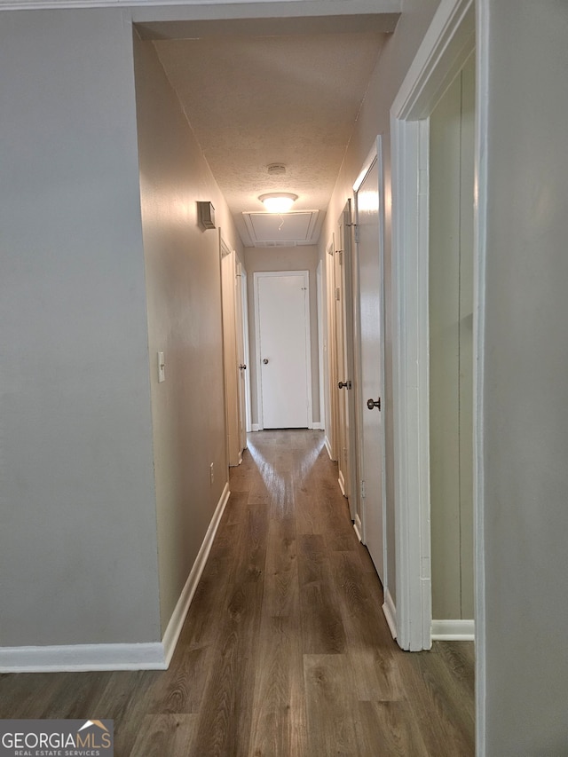 hallway with hardwood / wood-style flooring and a textured ceiling