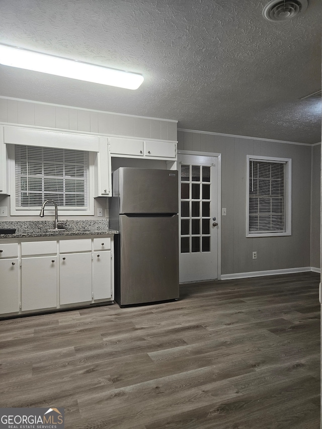 kitchen featuring sink, stainless steel fridge, dark hardwood / wood-style flooring, and white cabinetry