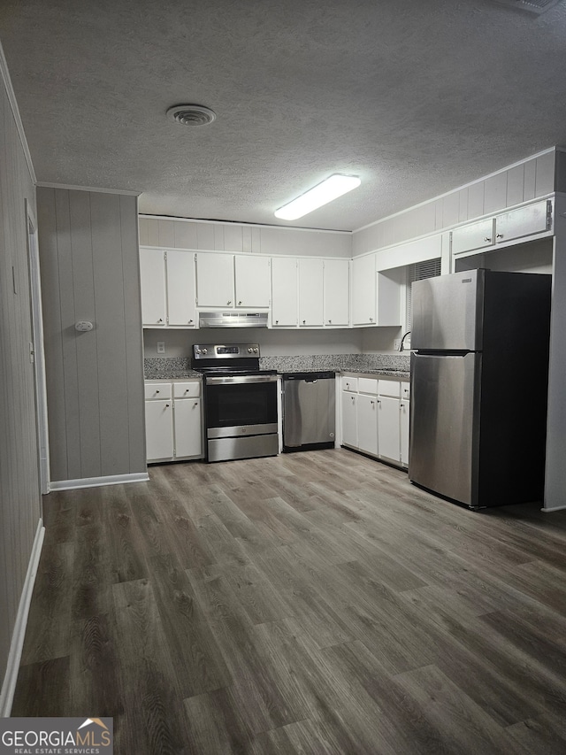 kitchen featuring a textured ceiling, wood-type flooring, stainless steel appliances, and white cabinets