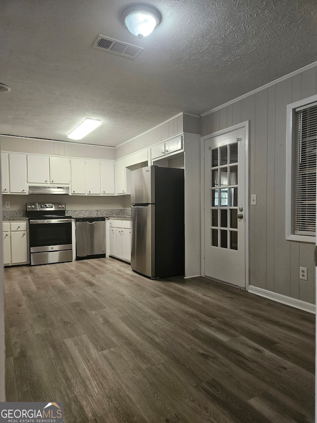 kitchen featuring stainless steel appliances, white cabinets, a textured ceiling, and dark hardwood / wood-style flooring