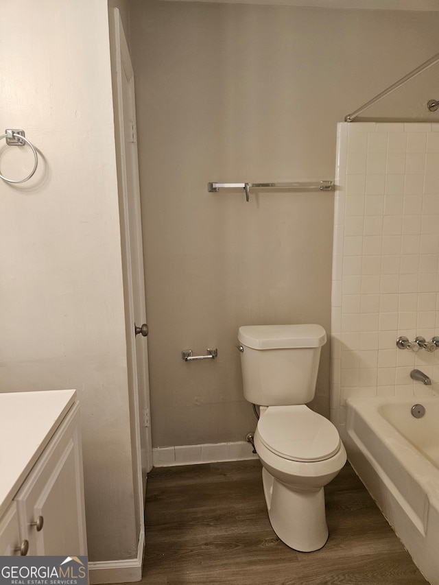 full bathroom featuring tub / shower combination, hardwood / wood-style floors, vanity, and toilet