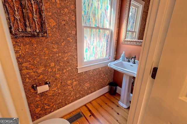 bathroom featuring hardwood / wood-style flooring, toilet, and a wealth of natural light