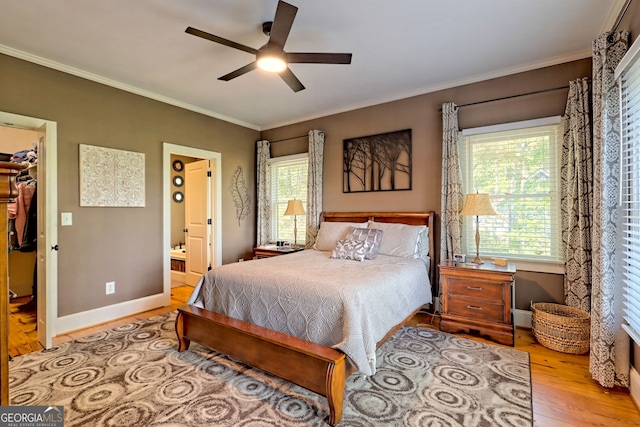 bedroom with ceiling fan, connected bathroom, a closet, a spacious closet, and light wood-type flooring