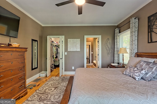 bedroom featuring a spacious closet, a closet, light wood-type flooring, ceiling fan, and ensuite bathroom