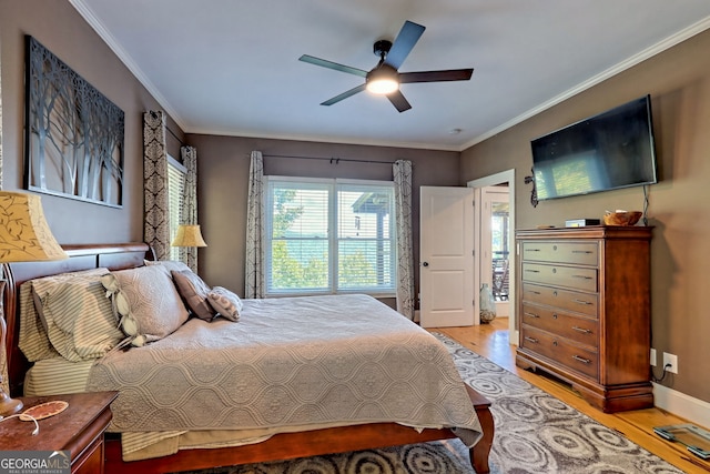 bedroom featuring light hardwood / wood-style floors, ceiling fan, and crown molding