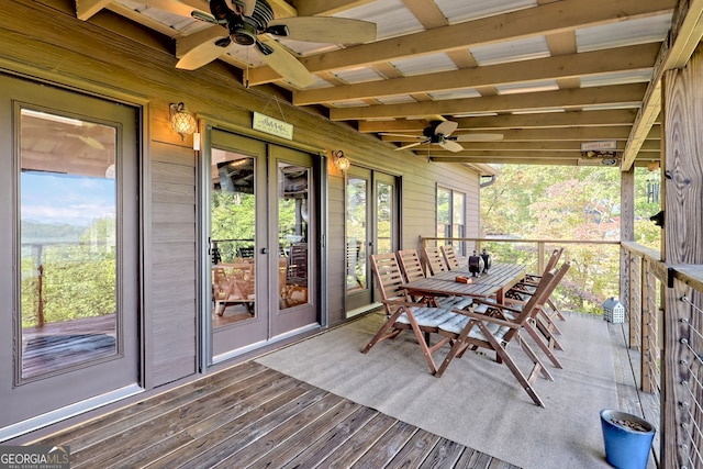 unfurnished sunroom with ceiling fan, beamed ceiling, and french doors