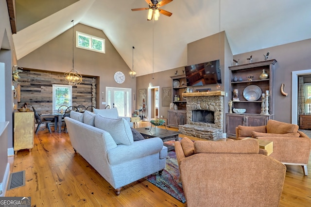 living room featuring light hardwood / wood-style flooring, a wealth of natural light, and a stone fireplace