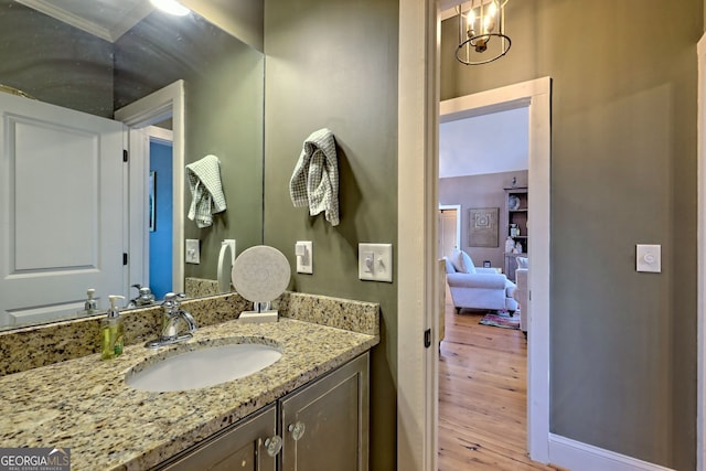 bathroom featuring ornamental molding, vanity, and hardwood / wood-style floors