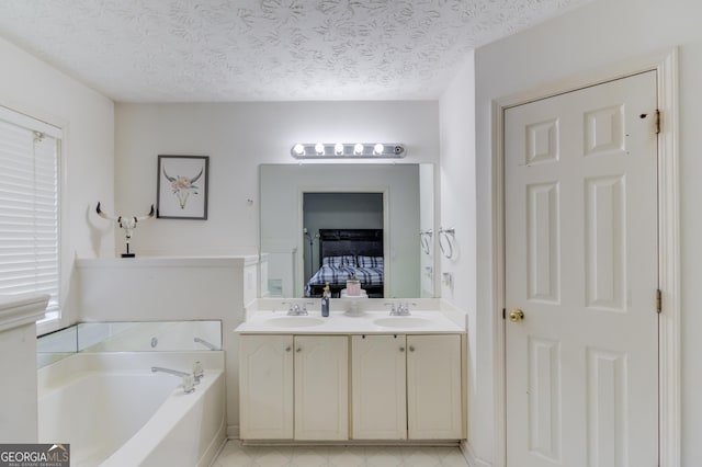 bathroom featuring vanity, a tub to relax in, and a textured ceiling