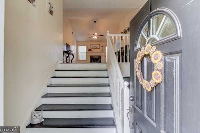 stairs with vaulted ceiling and ceiling fan