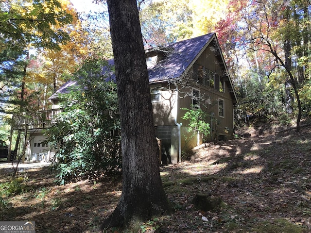 view of home's exterior featuring a garage and a wooden deck