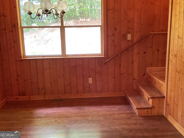 147 Wild Azalea Dr, Dillard, GA 30537 - staircase with a chandelier, wood finished floors, wood walls, and baseboards