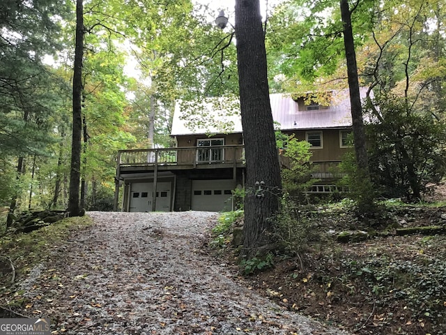 147 Wild Azalea Dr, Dillard, GA 30537 - rustic home with a garage, gravel driveway, a wooden deck, and metal roof