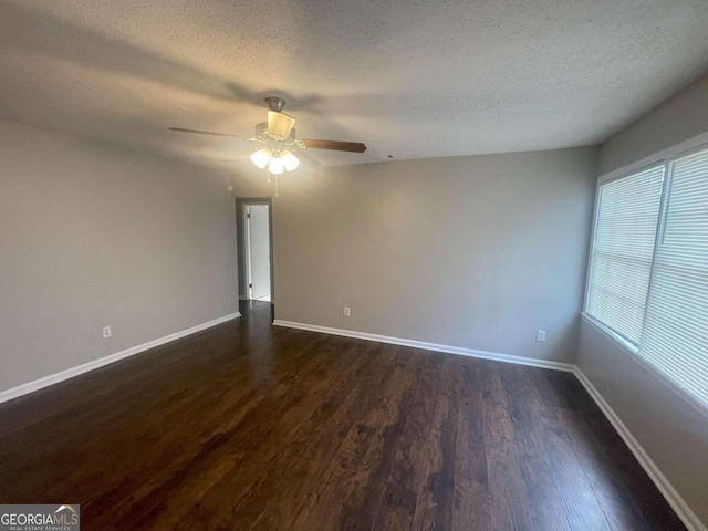 spare room with a textured ceiling, ceiling fan, and dark wood-type flooring