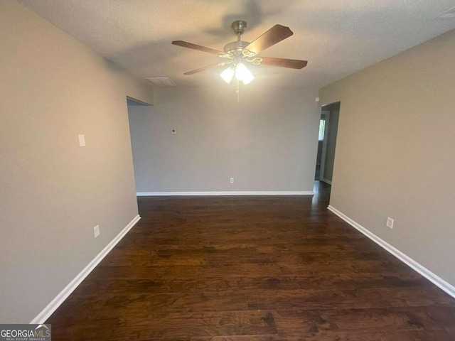 unfurnished room featuring a textured ceiling, dark hardwood / wood-style floors, and ceiling fan