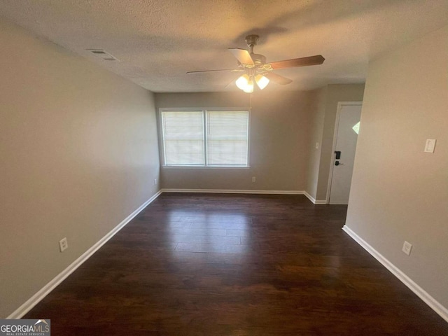 spare room with a textured ceiling, dark hardwood / wood-style flooring, and ceiling fan