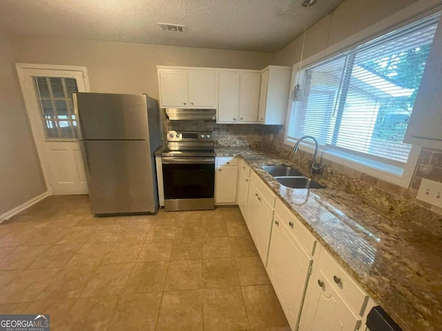 kitchen featuring sink, tasteful backsplash, stone counters, white cabinetry, and appliances with stainless steel finishes