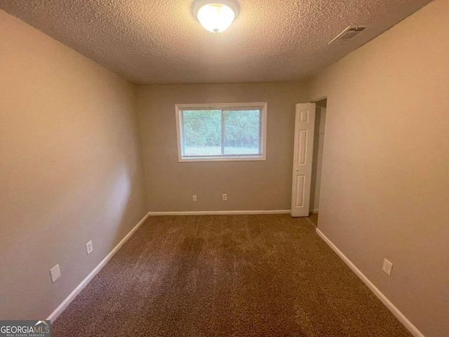 unfurnished room featuring carpet floors and a textured ceiling