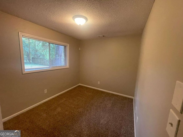 empty room with a textured ceiling and carpet