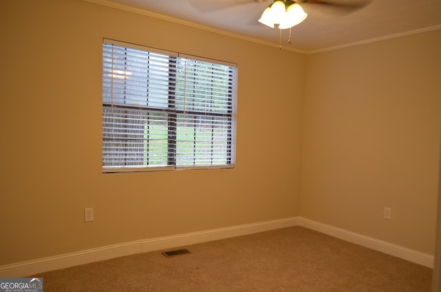 carpeted spare room featuring ornamental molding and ceiling fan