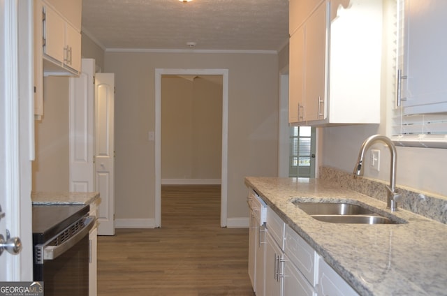 kitchen featuring white cabinetry, light stone countertops, light wood-type flooring, crown molding, and sink