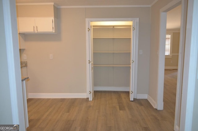 corridor featuring light hardwood / wood-style floors and crown molding