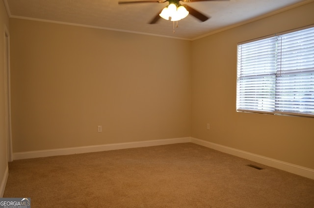 carpeted empty room featuring ceiling fan and ornamental molding