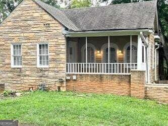 view of front of home with a front yard and a sunroom