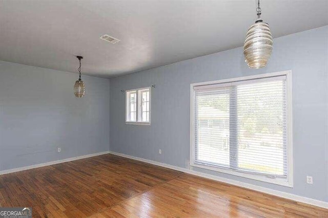 spare room featuring dark hardwood / wood-style floors and a wealth of natural light