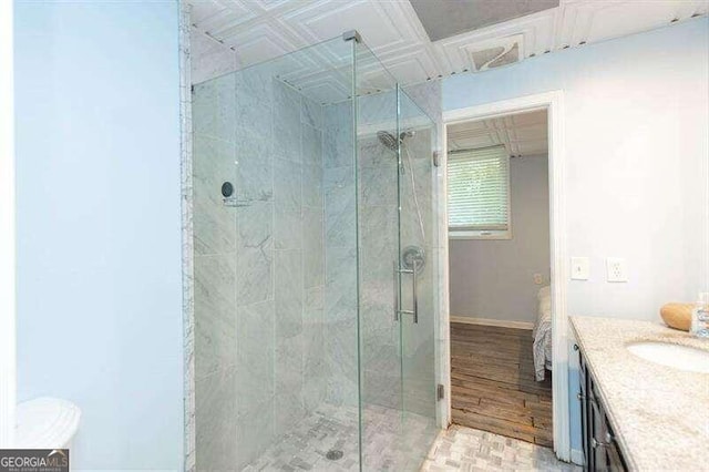 bathroom with vanity, hardwood / wood-style flooring, and a shower with door