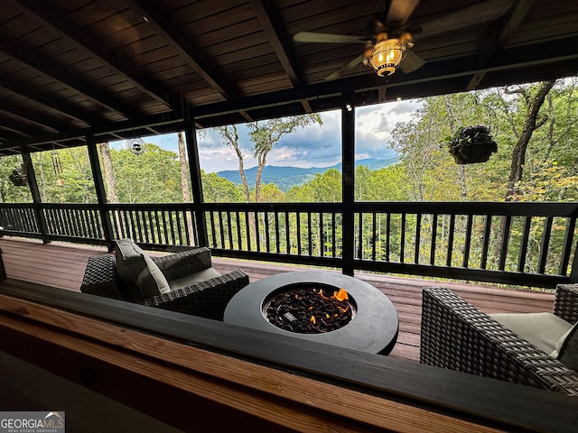 wooden terrace with ceiling fan and a fire pit