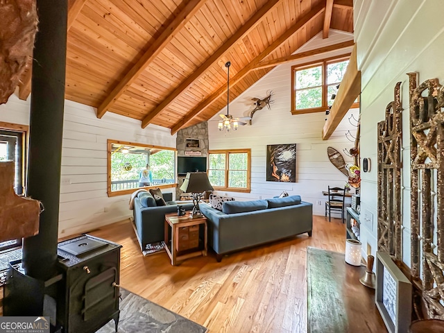 living room with beamed ceiling, hardwood / wood-style flooring, wooden walls, and wood ceiling