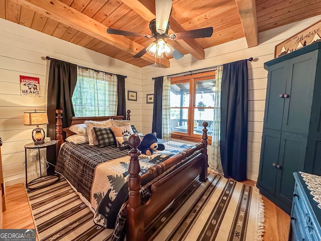 bedroom with wooden ceiling, wooden walls, ceiling fan, and multiple windows