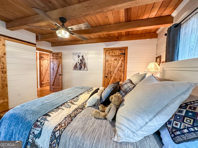 bedroom with wooden walls, ceiling fan, wooden ceiling, and beamed ceiling