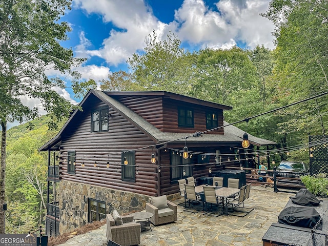 rear view of house with a patio area and outdoor lounge area