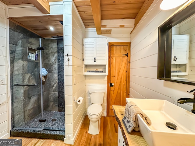 bathroom with hardwood / wood-style flooring, wooden walls, wood ceiling, beam ceiling, and sink