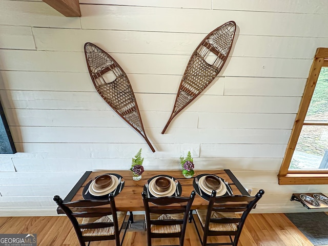 dining space featuring wooden walls and hardwood / wood-style floors