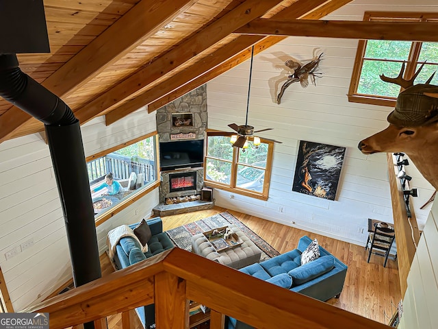 living room with vaulted ceiling with beams, wooden ceiling, hardwood / wood-style flooring, and plenty of natural light