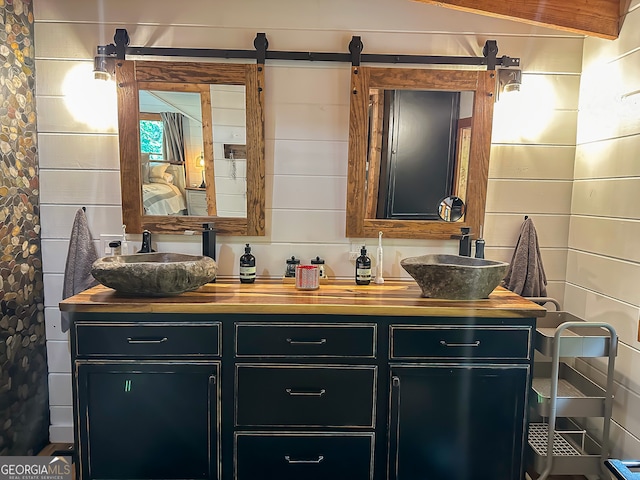 bathroom with vanity and wood walls