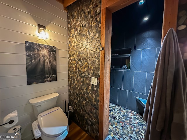 bathroom featuring toilet and wooden walls