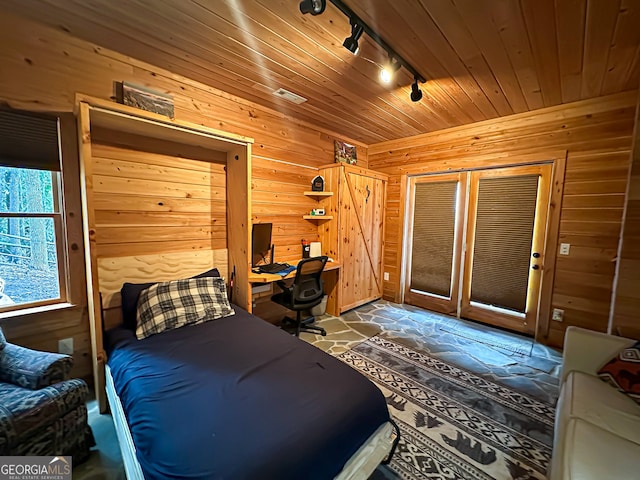 bedroom with rail lighting and wooden walls