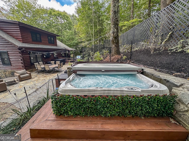 view of swimming pool with a hot tub and a deck