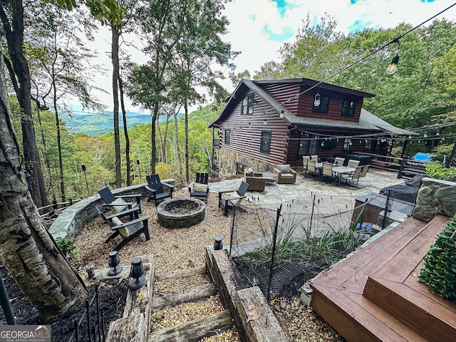 exterior space featuring an outdoor living space with a fire pit, a deck, and a patio area