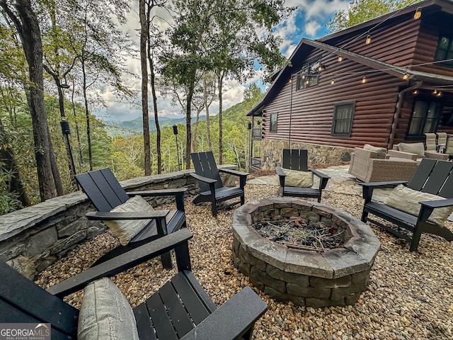 view of patio / terrace featuring an outdoor fire pit and a mountain view