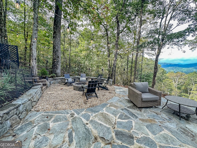 view of patio with an outdoor fire pit and a mountain view