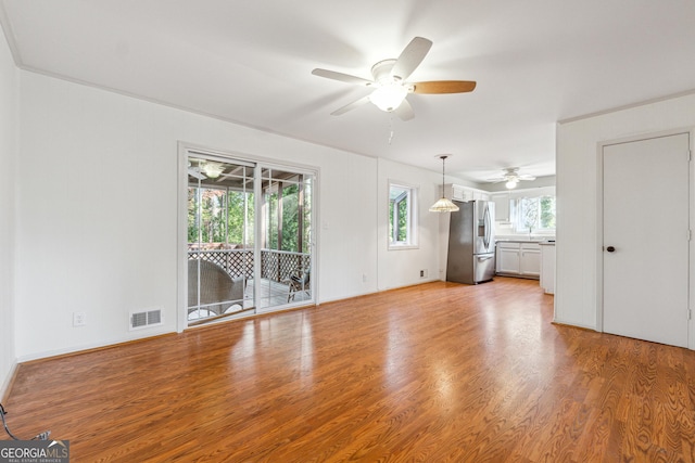 unfurnished living room featuring hardwood / wood-style floors and ceiling fan