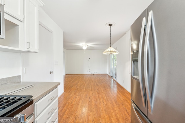 kitchen with white cabinets, ceiling fan, decorative light fixtures, light hardwood / wood-style floors, and stainless steel fridge with ice dispenser