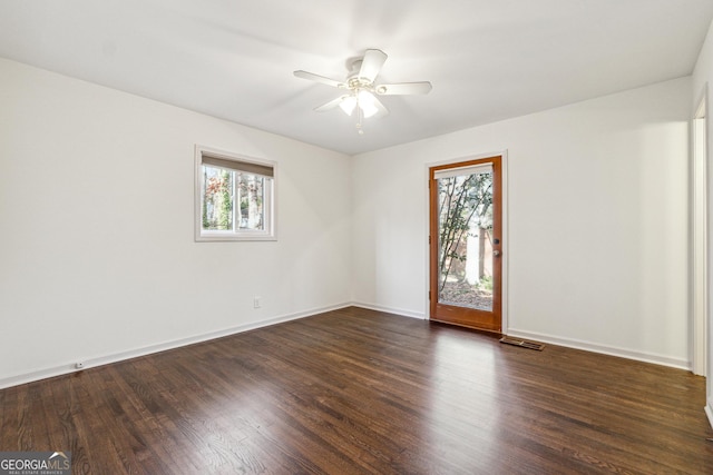 unfurnished room featuring dark hardwood / wood-style flooring, plenty of natural light, and ceiling fan