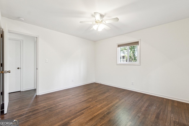 spare room with dark hardwood / wood-style flooring and ceiling fan