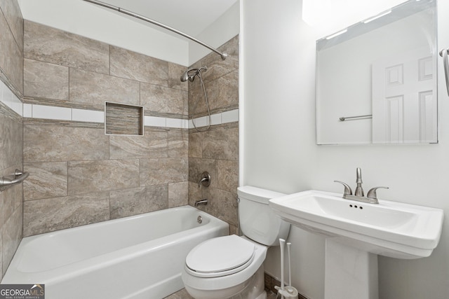 full bathroom with sink, tiled shower / bath, and toilet